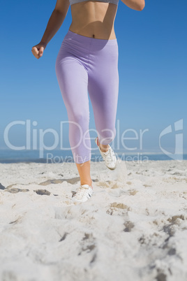 Sporty womans legs on the sand