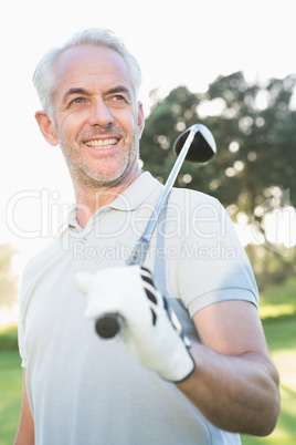 Smiling handsome golfer looking away