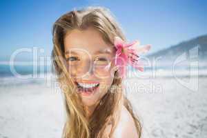 Beautiful smiling blonde with flower hair accessory on the beach