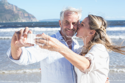 Married couple at the beach together taking a selfie
