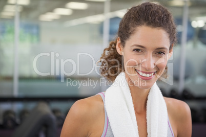 Fit woman smiling at camera with towel around shoulders