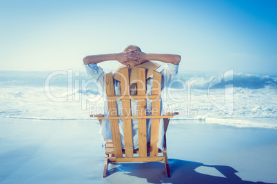 Woman relaxing in deck chair by the sea