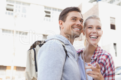 Young tourist couple smiling and pointing at something