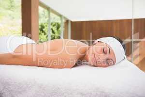 Beautiful calm brunette lying on massage table