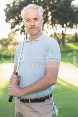 Smiling handsome golfer looking at camera