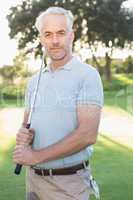Smiling handsome golfer looking at camera