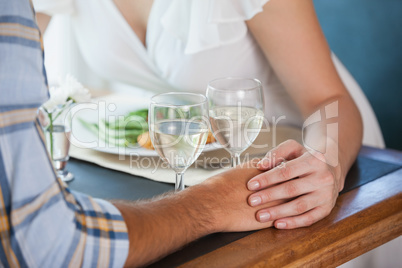 Couple holding hands at dinner