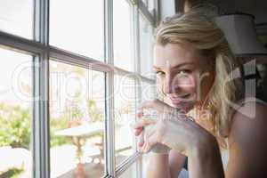 Pretty blonde sitting by the window having coffee