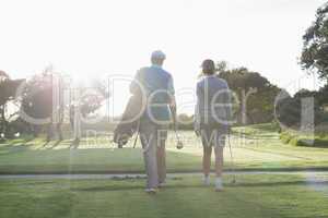 Golfing couple walking and chatting