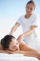 Calm brunette enjoying a massage poolside