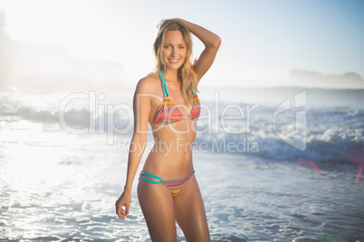 Happy blonde standing in the sea posing in bikini