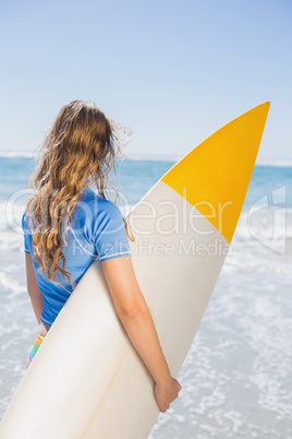 Fit surfer girl on the beach with her surfboard