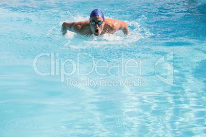 Fit swimmer doing the butterfly stroke in the swimming pool