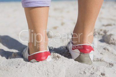 Sporty womans feet on the sand