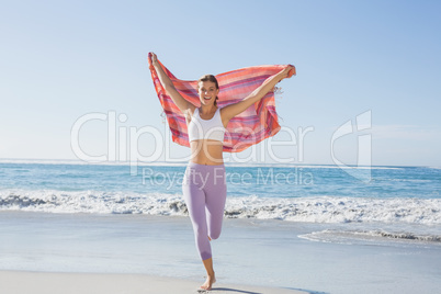 Sporty blonde standing on the beach with a scarf