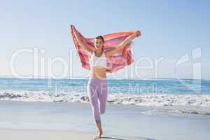 Sporty blonde standing on the beach with a scarf