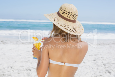 Woman holding cocktail on the beach