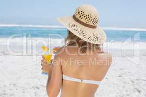 Woman holding cocktail on the beach