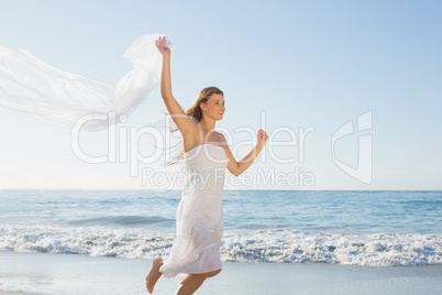 Beautiful smiling blonde in white sundress on the beach with sca