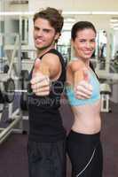 Fit attractive couple giving thumbs up to camera
