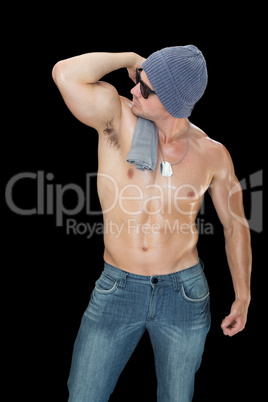 Muscular man posing in blue jeans hat and sunglasses