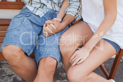 Young hip couple sitting on bench