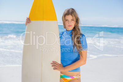 Fit surfer girl on the beach with her surfboard