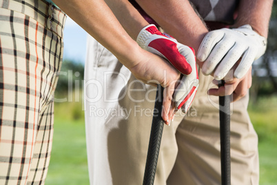 Golfing couple standing holding their clubs