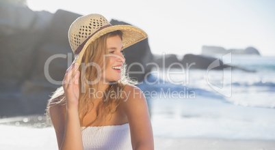 Beautiful smiling blonde in sundress sitting on the beach