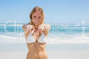 Beautiful blonde smiling at camera on the beach