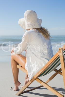 Blonde relaxing in deck chair by the sea