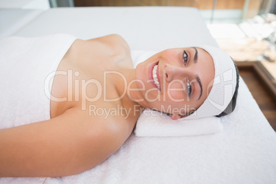 Peaceful smiing brunette lying on massage table