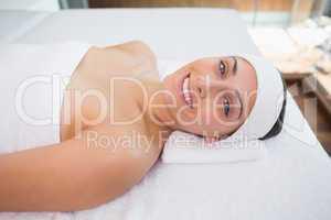 Peaceful smiing brunette lying on massage table