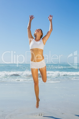 Gorgeous fit blonde jumping by the sea