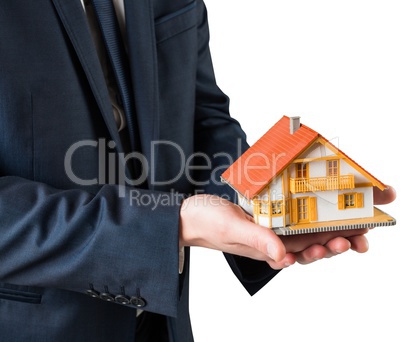 Businessman holding miniature house model