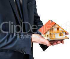 Businessman holding miniature house model