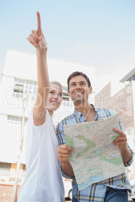 Young tourist couple looking at map and pointing