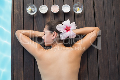 Tranquil brunette poolside with beauty treatments