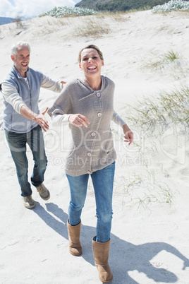 Attractive couple playing chasing on the beach