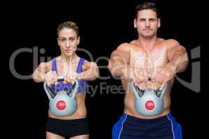Crossfit couple posing with kettlebells