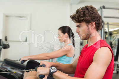 Focused man working out on the rowing machine