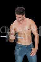 Muscular man lifting dumbbell in blue jeans