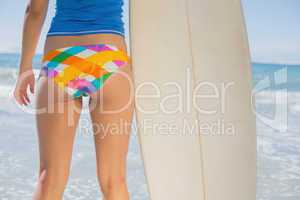 Fit surfer girl on the beach with her surfboard