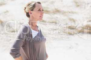 Thinking blonde woman standing on the beach