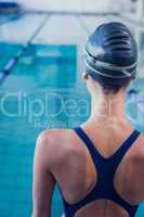 Pretty swimmer standing by the pool