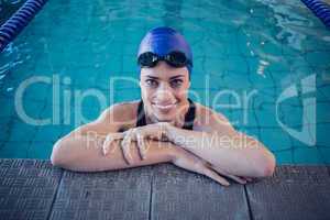 Fit swimmer in the pool smiling at camera