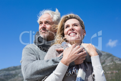 Carefree couple hugging in warm clothing
