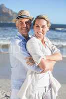 Happy couple standing on the beach together