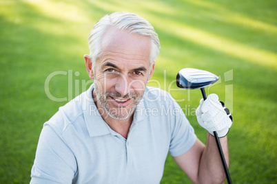 Handsome golfer smiling up at camera