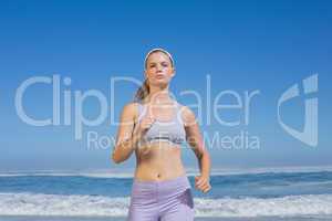 Sporty focused blonde jogging on the beach